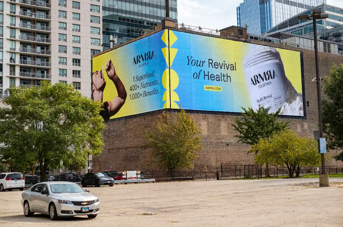 ARMRA billboard on a building wall above a parking lot