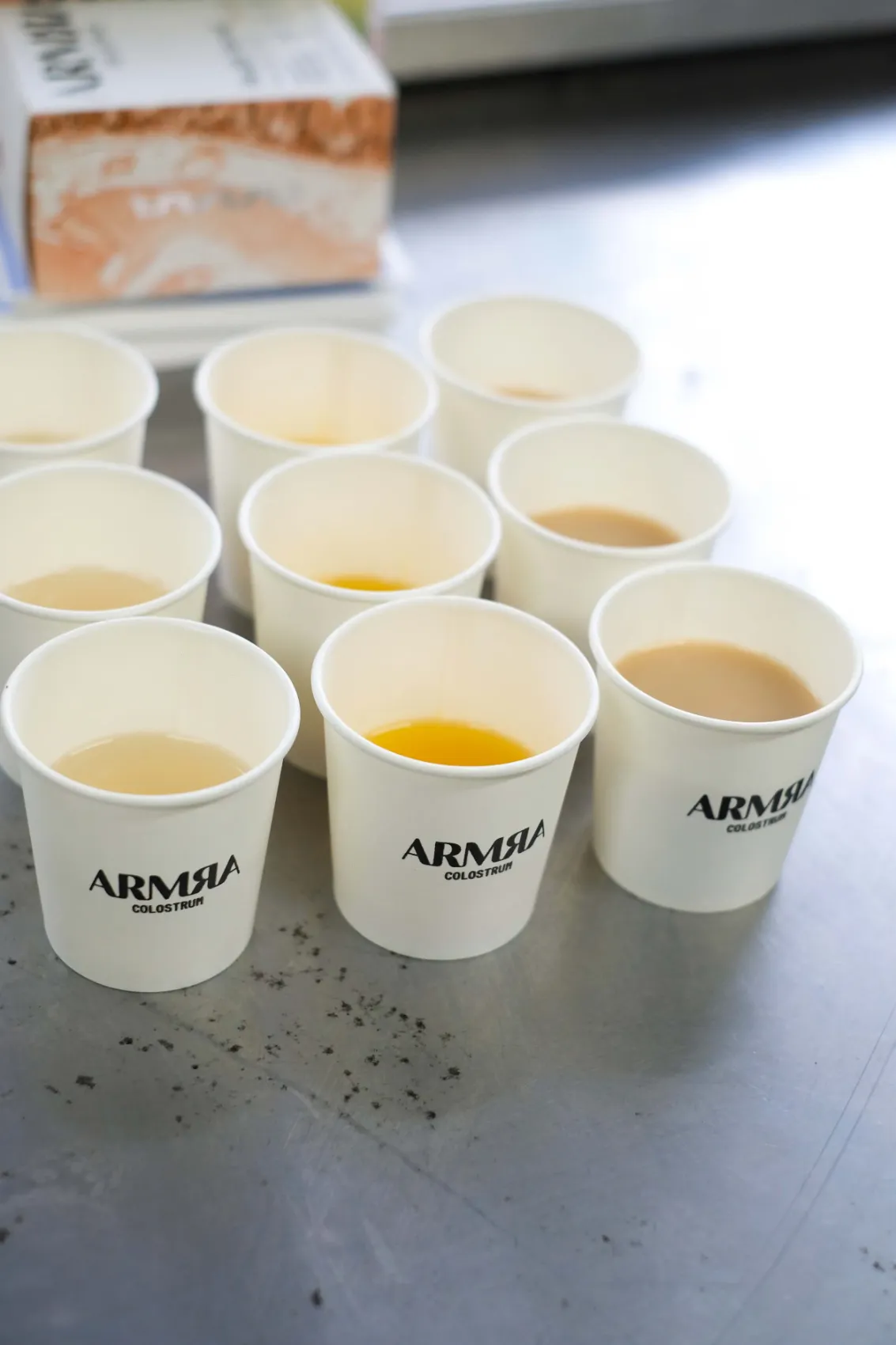 Paper sample cups of ARMRA drinks on a table