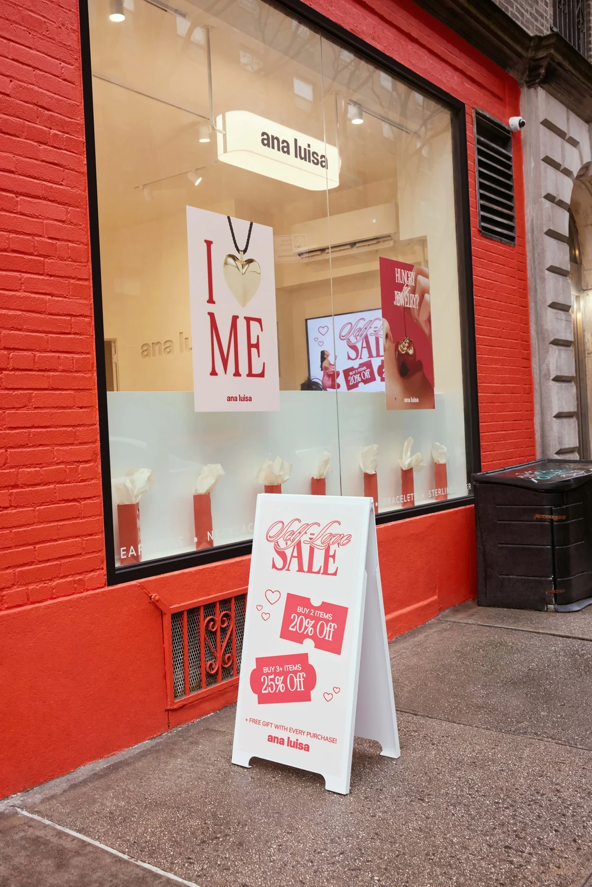 Red storefront window with posters and a sale sign
