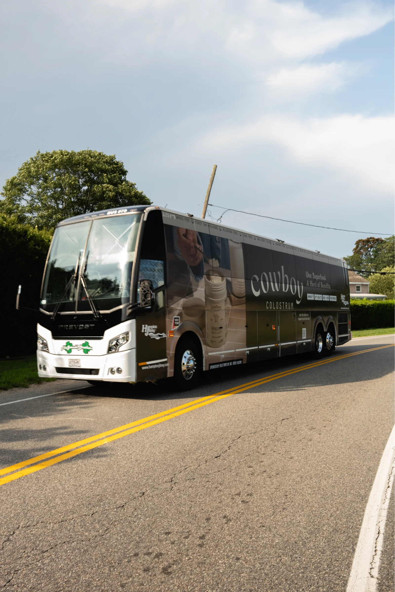 The wrapped coach coming round a bend on a two-lane road