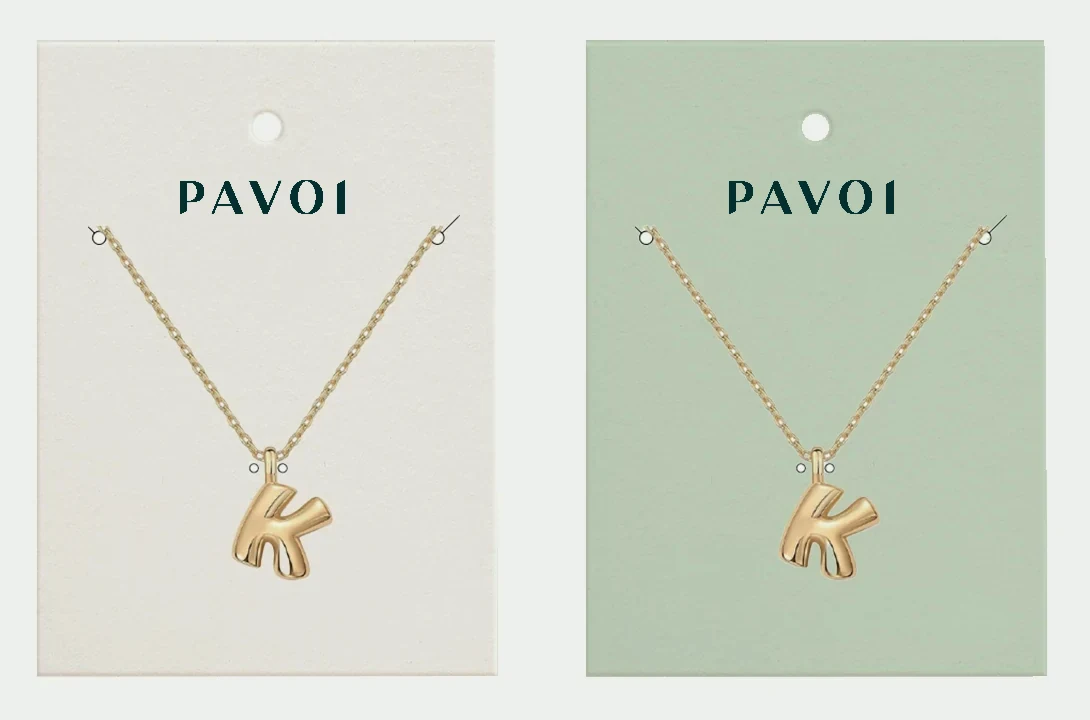 PAVOI necklace cards in cream and sage, each holding a gold initial pendant